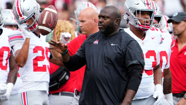 Ohio State running backs coach Tony Alford flips a ball during a game.